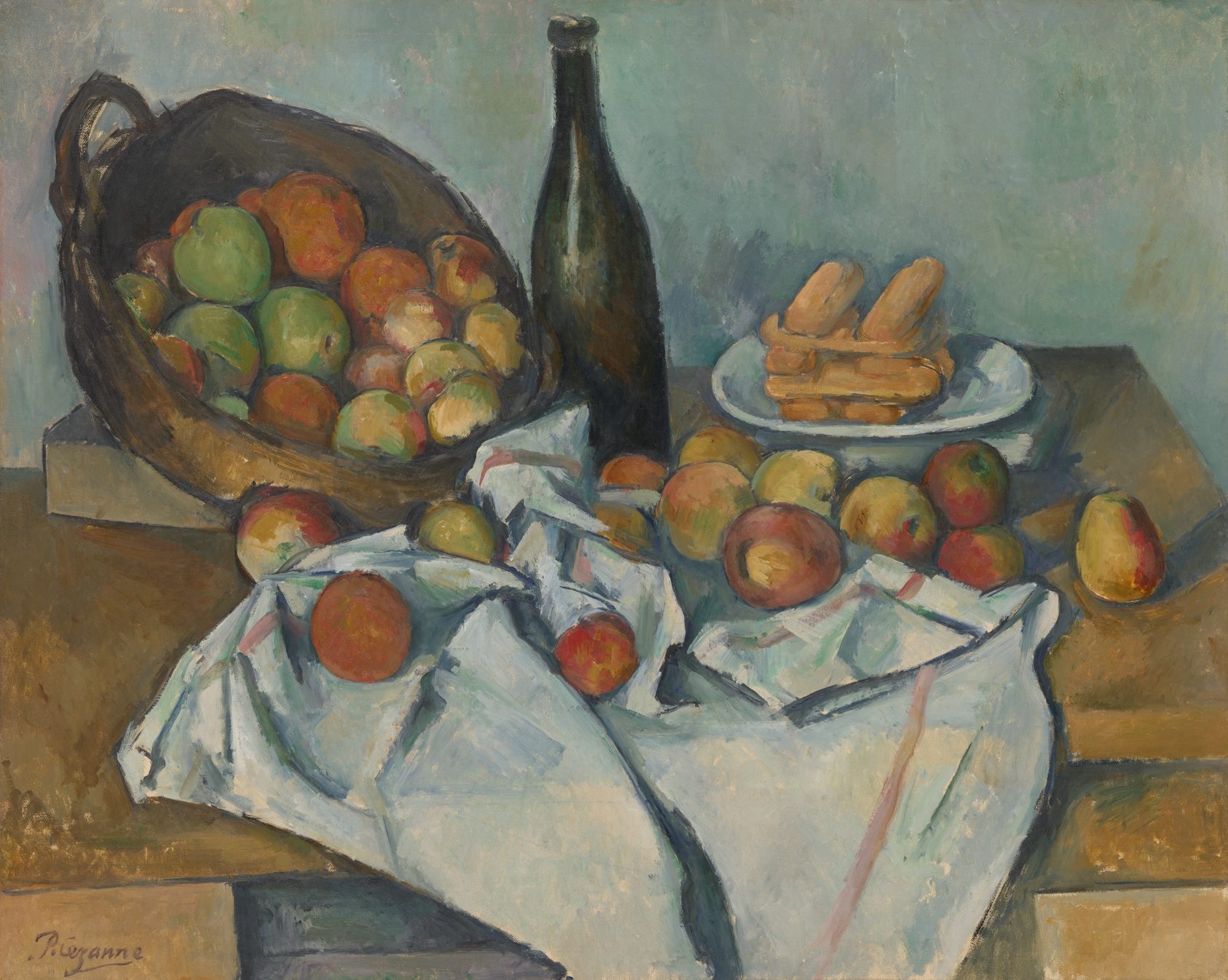 Apples spilling from a tilted basket across a table, beside a bottle and a plate of biscuits.